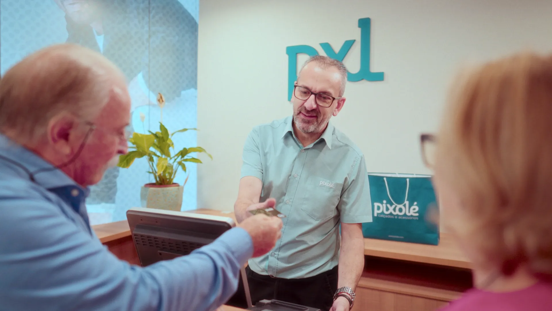 PIXOLÉ 50 anos — atendimento a um casal no balcão